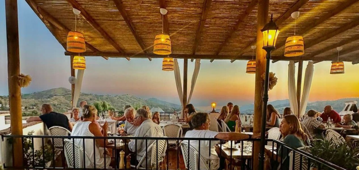 Atardecer en la terraza de Cortijo Paco con vistas panorámicas a las montañas de Cómpeta